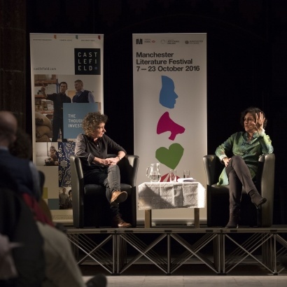 Distant image of Jeanette Winterson and Kamila Shamsie looking at each other on stage