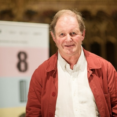 Image of author Michael Morpurgo standing and smiling on stage at MLF 18