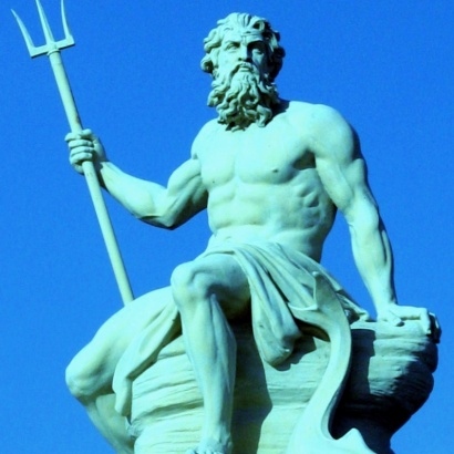 A statue of Poseidon against a backdrop of a sunny day