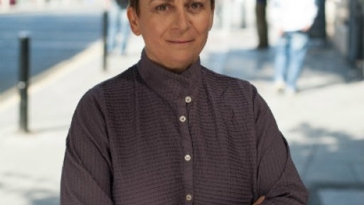 Image of Anne Enright stood on a pavement with people in the background