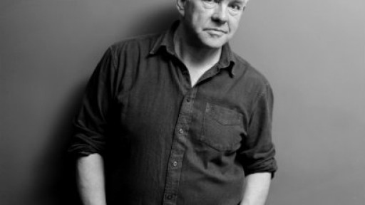 Image of Ian McMillan with his back against a wall and his hands in his pockets