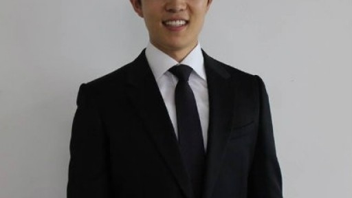 Image of Sungju Lee from the waist up, dressed in a formal suit and tie and smiling