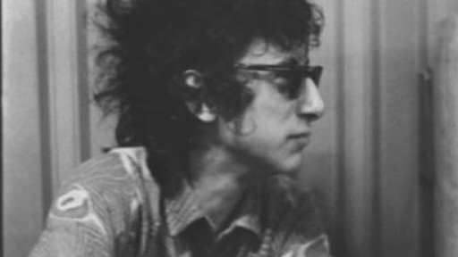 Black and white image of John Cooper Clarke in sunglasses, looking completely off camera