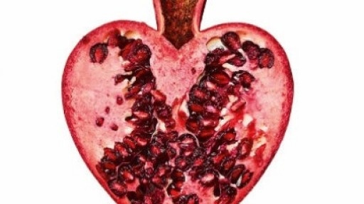 Image of the front cover of Reader, I Married Him showing a pomegranate cut in half in the shape of a heart, on a white background