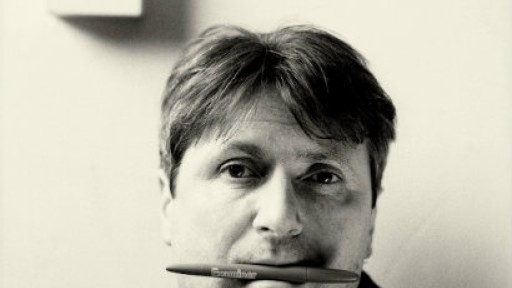 Head and shoulders image of Simon Armitage with a pen in his mouth
