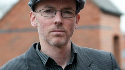 Author Jon McGregor looking serious in a flat cap