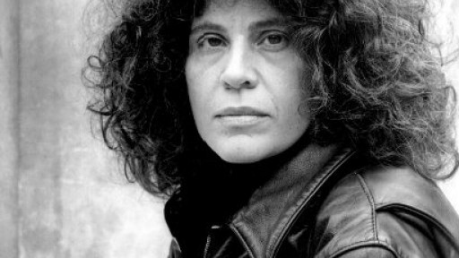 Black and white image of Anne Michaels looking serious in a leather jacket