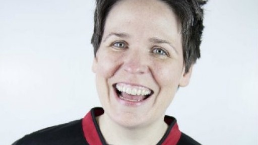Image of Comedy Club 4 Kids' Kate McCabe in a red and black football shirt, and grinning at the camera