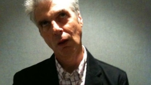 Picture of Jon Savage stood under a spotlight, rolling his eyes up at the ceiling
