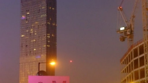 Image of Manchester by night, with the Beetham Tower and a crane in the background