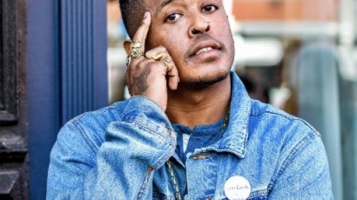 Image of Danez Smith standing in the street in a blue denim jacket