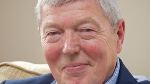 Image of a smiling Alan Johnson in a blue suit and shirt
