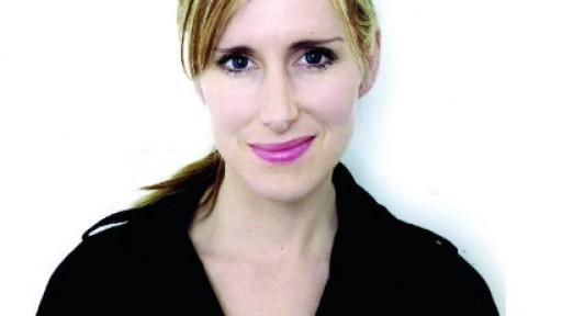 Head shot of children's author and illustrator Lauren Child, wearing a black shirt against a white background, smiling