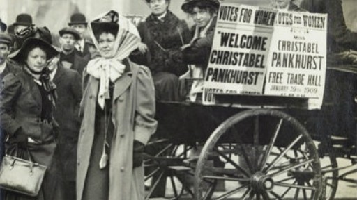 Back and white image of suffragettes protesting with banners in the street, circa 1909