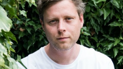 Headshot of author Max Porter against a background of greenery