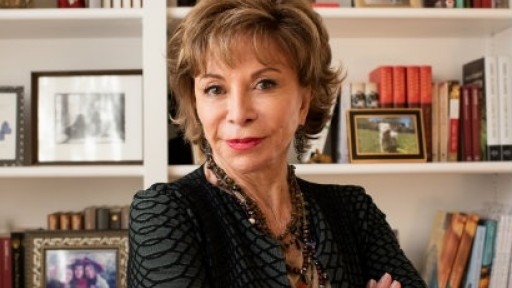 Head and shoulders shot of author Isabel Allende in front of bookcases