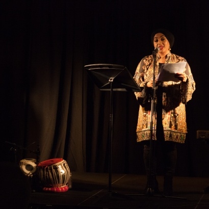 Image of poet Hafsah Aneela Bashir performing on stage as part of Rewritign Longsight commission