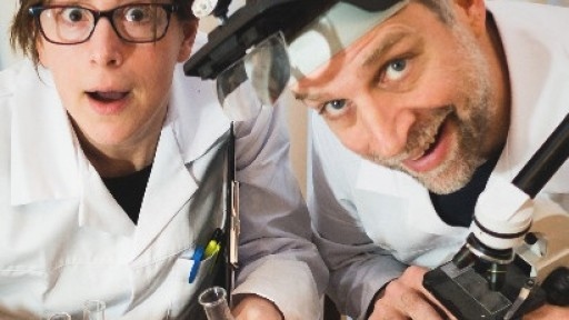 Photo of authors Sue Henra and Paul Linnet dressed as scientists and holding test tubes and science equipment