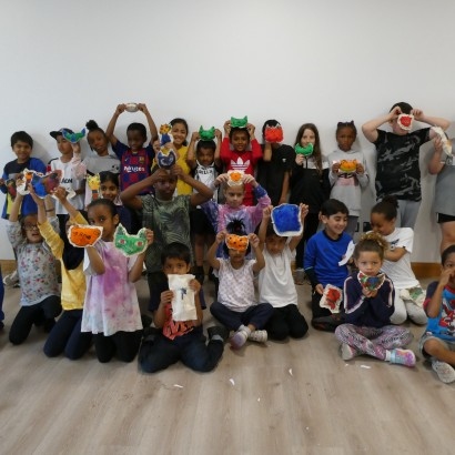 Group of children holding up cat cushions they made