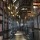 Atmospheric photo of a corridor lined with black bookshelves and fabric bound hardbacks in the historic Chethams Library