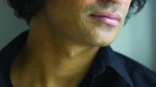 Close-up portrait of writer Nadeem Aslam looking pensive in a black shirt
